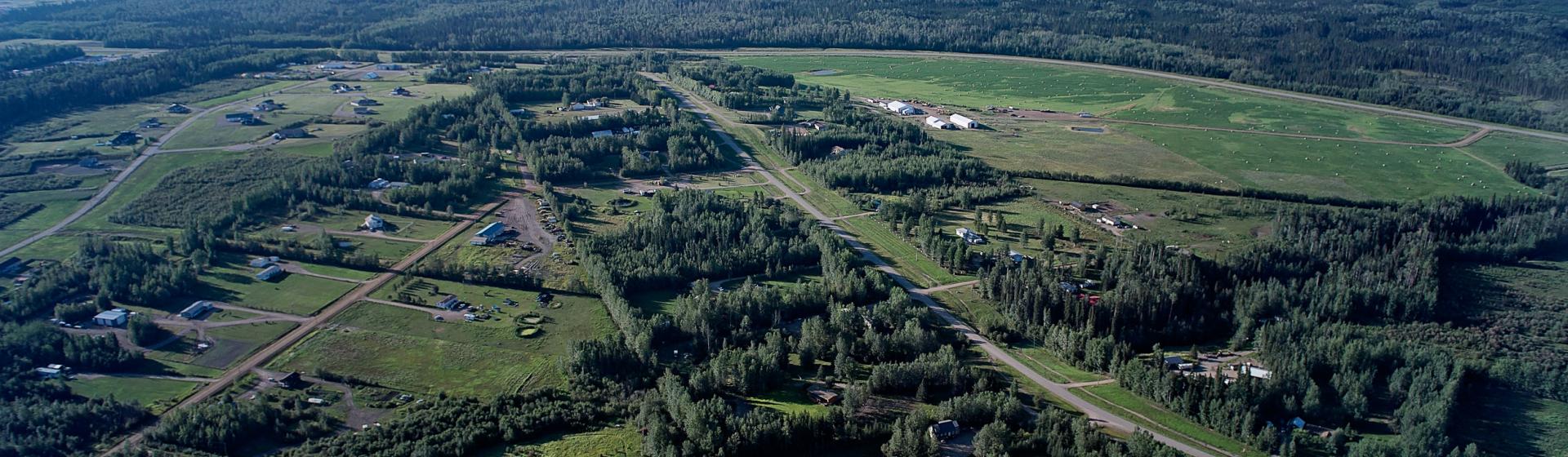 Aerial view of a coastal town with buildings, trees, and a water